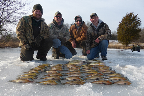 A group of ice fishermen pose behind their catch for the day.