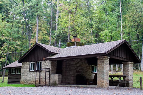A wood and stone cabin is near the forest at Clear Creek State Park.