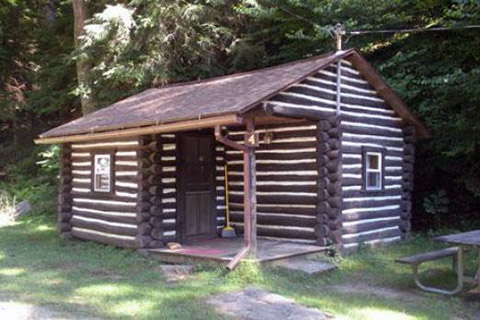 A log cabin is near the forest at Cook Forest State Park.