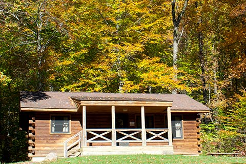 A modern log cabin is near the forest at French Creek State Park.