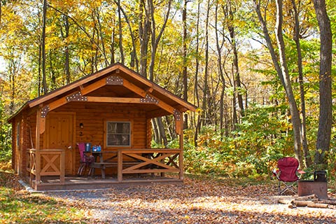 A cozy log cabin is in the forest at French Creek State Park.