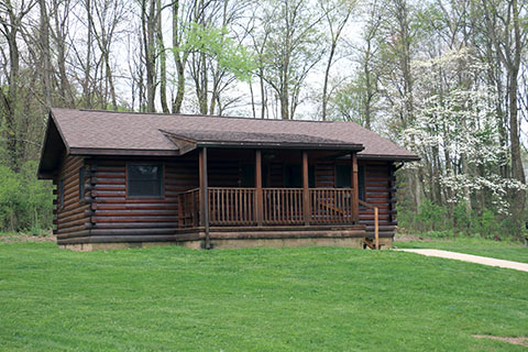 A modern log cabin is near trees at Keystone State Park.