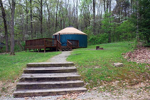 Up a flight os steps is a round tent with a wooden porch at Keystone State Park.