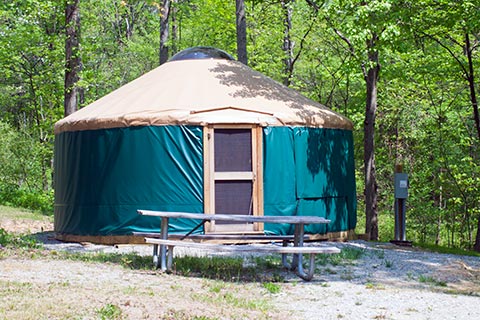 A round tent with a door is near a forest at Ohiopyle State Park.