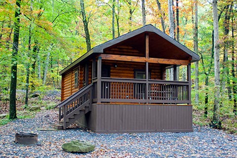 A cozy log cabin is surrounded by a forest at Poe Valley State Park.