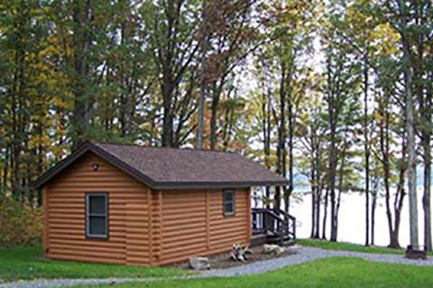 A cozy log cabin has a lake view at Prince Gallitzin State Park.