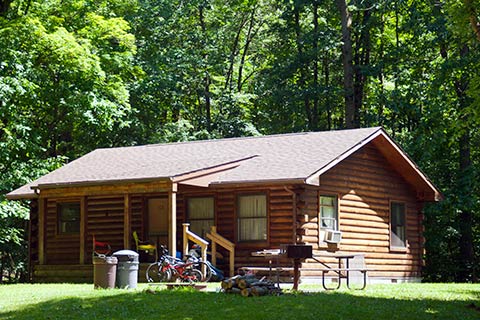 Bikes are in front of a modern log cabin at Pymatuning State Park.