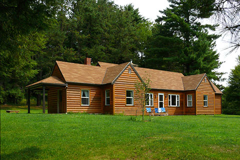 A very large log cabin is near the forest at Raccoon Creek State Park.