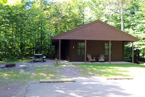 A modern log cabin is near a forest at Ricketts Glen State Park.