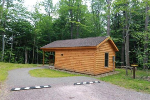 A cozy log cabin is near a forest at Ricketts Glen State Park.