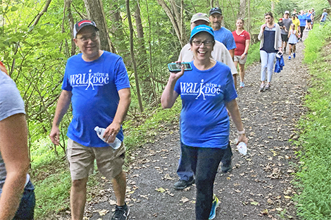 Nature, outdoors, people, walking, trail, woods, trees, path, smiles, T shirts with text that says "Walk with a Doc"
