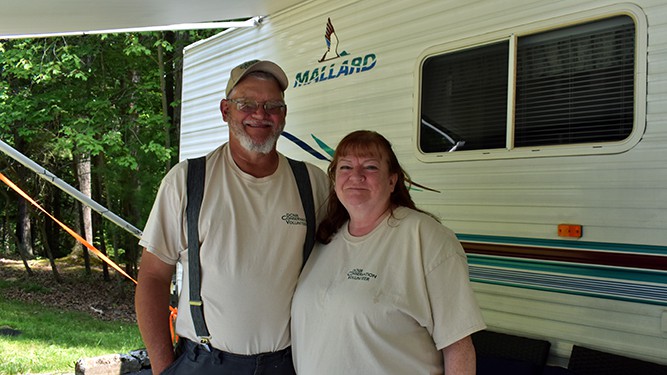 Lana and Gary Klingensmith post for photo next to their RV.