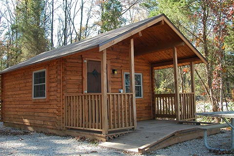 A cozy log cabin is near woods at Gifford Pinchot State Park.