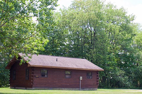 A modern log cabin is near a forest at Nockamixon State Park.